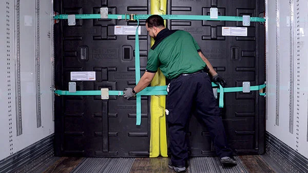 Driver Securing Security Divider in Freight Truck
